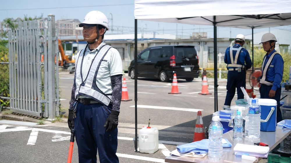 屋外で立ち仕事をする警備員や誘導スタッフの暑さ対策イメージ