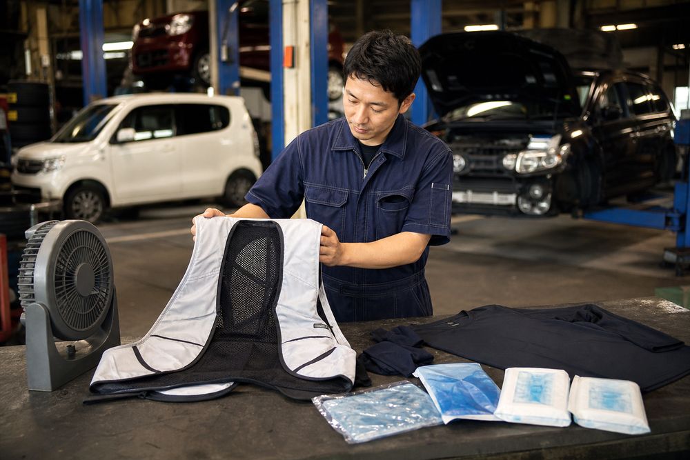 自動車整備工場で整備士の熱中症対策用品を確認するイメージ